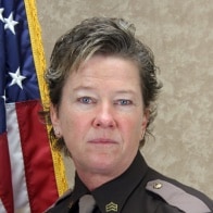 Captain Bridget Foy in uniform in front of a U.S. flag.