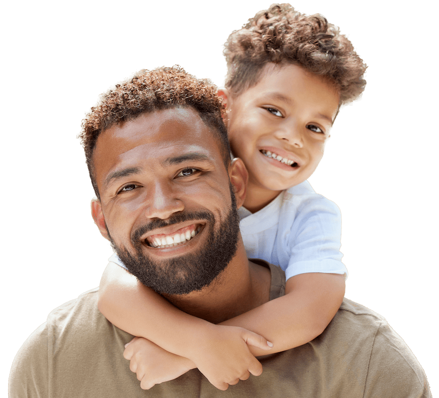 A young boy hangs on his smiling father's back.