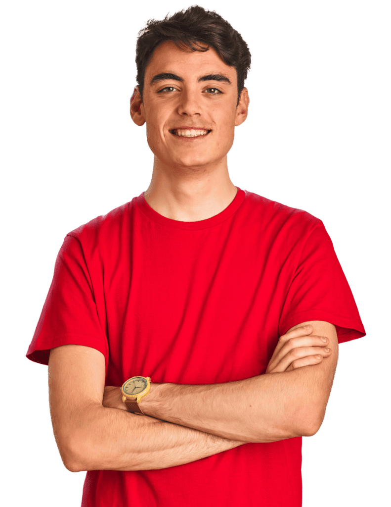 A teen boy in a red shirt stands with arms crossed smiling at the camera.